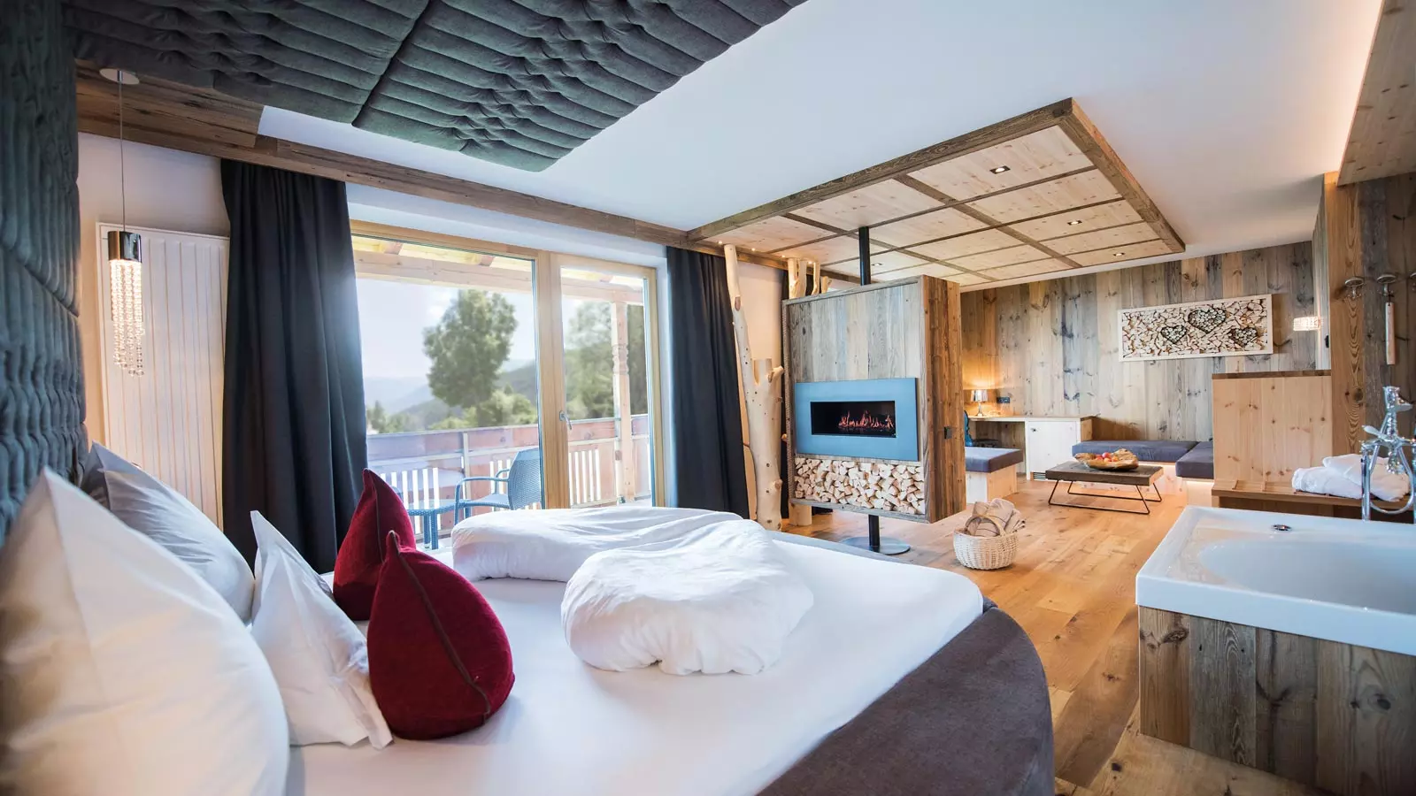 Romantiksuite des Parkhotel Holzerhof in Holz und Naturmaterialien eingerichtet und einem Queensize Bett