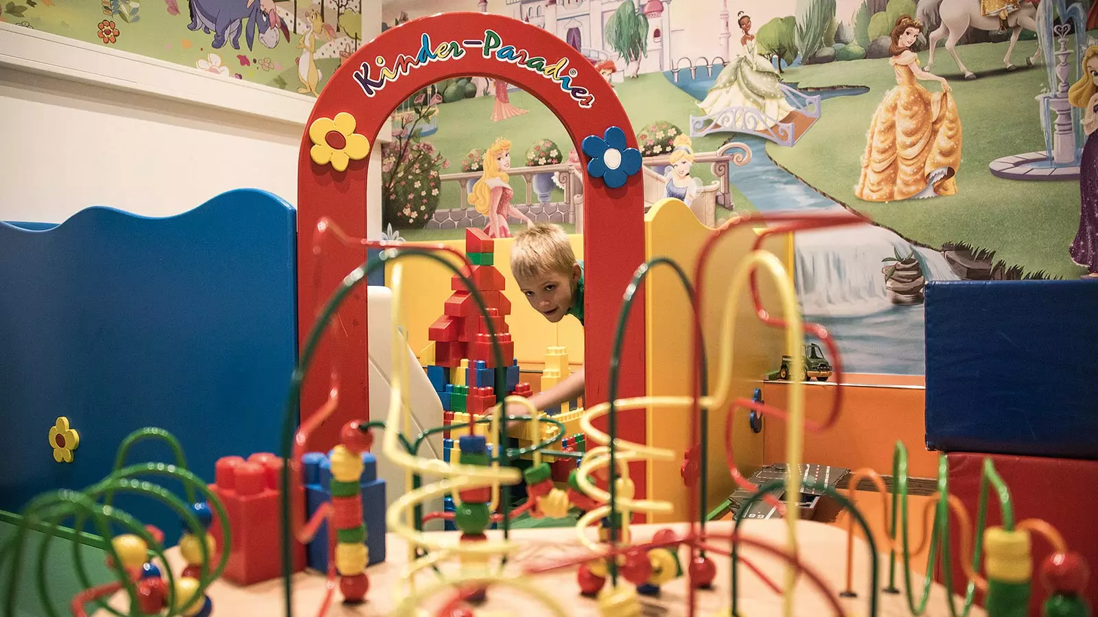 ein blondes Kind spielt im Spielzimmer des Familienhotels Holzerhof